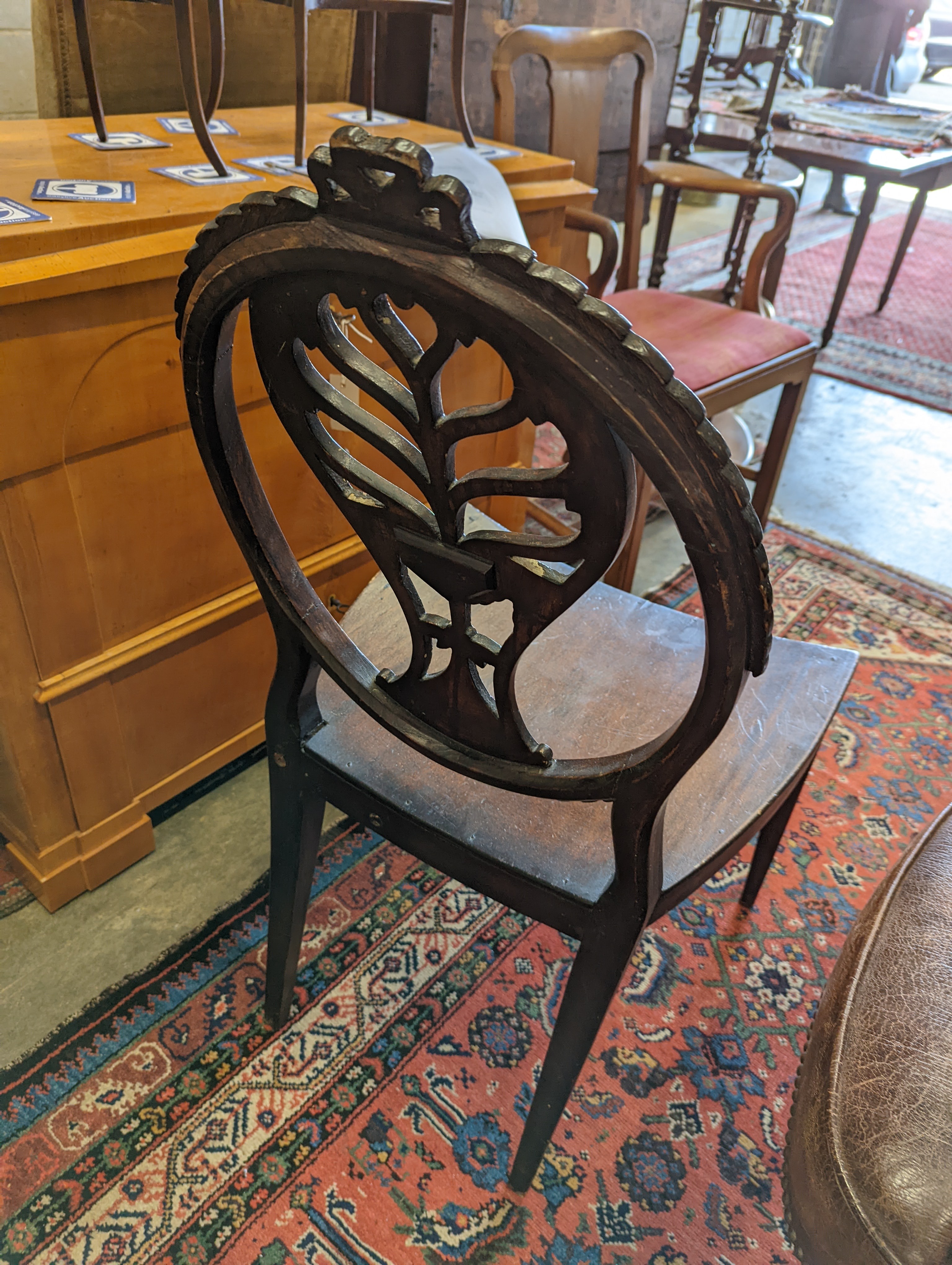 A brown leather upholstered desk chair, a mahogany hall chair and two upholstered armchairs